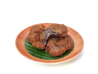 Gemblong cake or Indonesian traditional cakes made from glutinous rice flour grated coconut and palm sugar on wooden plate isolated on white background. High angle view 