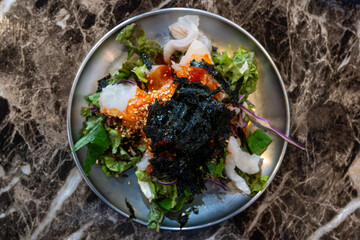 sashimi salad with raw fish, laver, vegetable and gochujang sauce