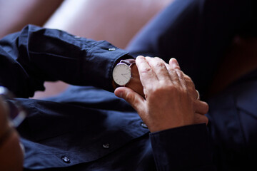 腕時計で時間を確認する日本人シニア男性の手元