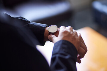 腕時計で時間を確認する日本人シニア男性の手元