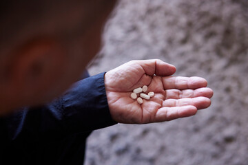 錠剤の薬と日本人シニア男性の手元