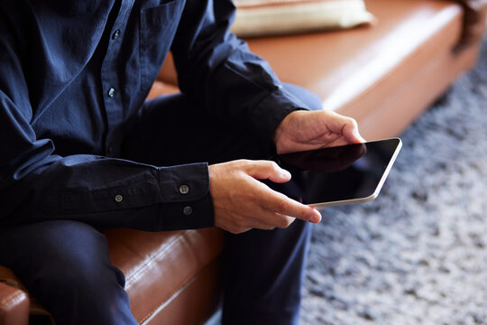 タブレット端末を操作する日本人シニア男性の手元