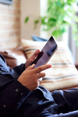 タブレット端末を操作する日本人シニア男性の手元