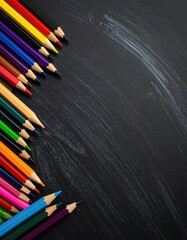 A vibrant array of colored pencils neatly arranged along the edge of a scratched black surface, suggesting creativity or learning