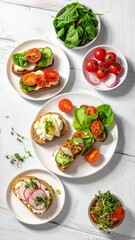 A bright, top-down shot of varied open-faced sandwiches artistically arranged with vibrant vegetables on a white wooden surface