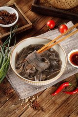 Shaanxi Style Buckwheat Noodles with Red Peppers and Traditional Chinese Spices on Wooden Background