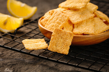 Homemade Golden Crispy Crackers in Wooden Bowl with Lemon on Cooling Rack
