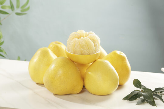 Fresh Yellow Pomelo Citrus Fruits with Peeled Segments on White Table