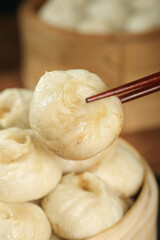 Traditional Chinese Xiao Long Bao Soup Dumpling with Chopsticks in Bamboo Steamer