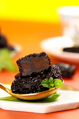 Big Crystal Black Xinjiang Dried Jujube Dates with Mint Garnish on Golden Spoon