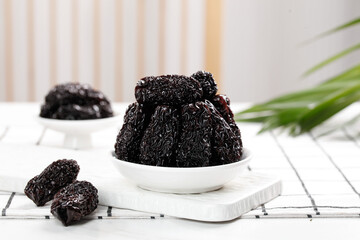 Dried Black Jujube Dates in White Bowl - Traditional Chinese Superfood on Wooden Board