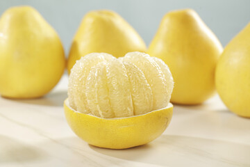 Fresh Pomelo Citrus Fruit Peeled Segments in Natural Rind Bowl with Whole Fruits