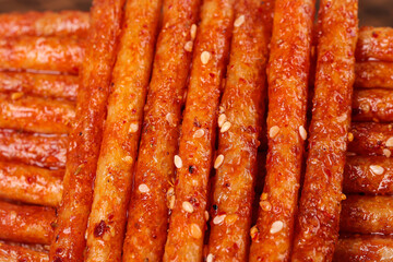 Spicy Glazed Asian Snack Sticks with Sesame Seeds - Traditional Street Food Delicacy
