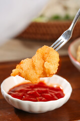 Crispy Golden Chicken Nugget on Fork with Red Dipping Sauce