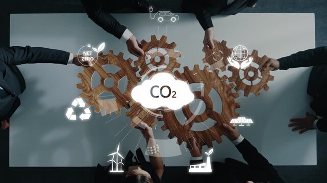 A diverse business team engages in a meeting focused on sustainable strategies, using gears and environmental icons to visualize their plan for net zero carbon emissions. Raster
