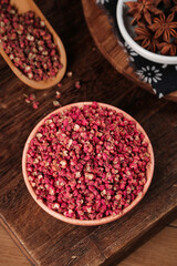 Sichuan Peppercorns and Star Anise Spices in Wooden Bowls on Rustic Wood Table