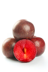 Fresh Red Chilean Plums with Cut Open Fruit Showing Red Flesh on White Background