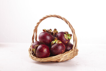 Fresh Mangosteen Tropical Fruit from Thailand in Wicker Basket on White Background