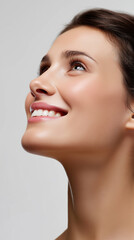 Obraz premium Smiling woman looking upwards with glowing natural skin. 