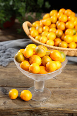 Fresh Kumquats in Glass Bowl and Wicker Basket on Rustic Wooden Table