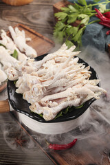 Fresh Chicken Feet in Hot Pot with Steam and Asian Cooking Ingredients