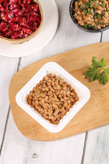 Japanese Natto Fermented Soybeans with Chili Peppers Traditional Healthy Food on Wooden Board