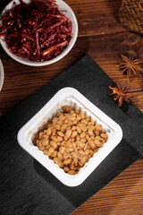 Japanese Natto Fermented Soybeans with Spices on Rustic Wooden Table