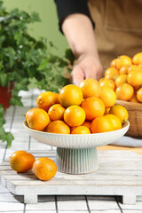 Fresh Sweet Kumquats in White Bowl on Rustic Wood Table - Healthy Citrus Fruit Display