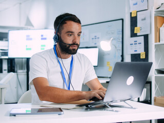 Male Call Center Operator working in office, Providing Customer Service Support, Consulting Clients, Telemarketing Service, Using Computer and Headset, Remote Consulting on Desktop Computer at Office
