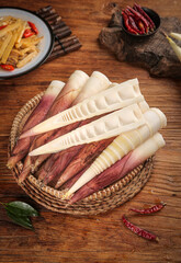 Fresh Handpeeled Bamboo Shoots in Wicker Basket with Asian Cooking Ingredients on Rustic Wooden Table