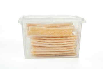 Dried pasta sheets in transparent storage container on white background