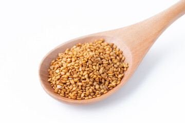 白背景にスプーンに載せた金ごま（生ごま）のクローズアップ