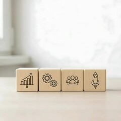 Four wooden blocks with business concept icons representing growth process teamwork and startup on a white surface