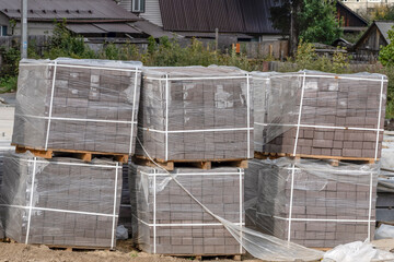 Pallets with construction materials are stored at the construction site on an autumn day