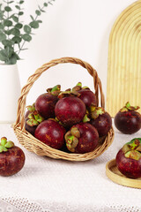 Fresh Thai Mangosteen Tropical Fruit in Wicker Basket on White Marble Kitchen Counter