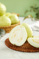 Fresh White Guava Fruit Sliced in Half Showing Creamy Interior on Wicker Mat