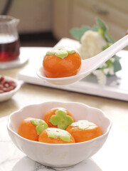 Sweet persimmon dessert soup with green garnish traditional Chinese cuisine Asian sweets