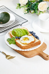 Heart-Shaped Egg Avocado Toast Creative Breakfast Combination with Blueberries and Mint on Wooden Board