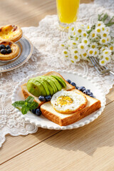 Heart-Shaped Egg and Avocado Toast Breakfast with Blueberries on Wooden Table