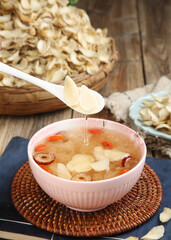 Silver fungus lily soup with red dates traditional Chinese dessert being served with wooden spoon