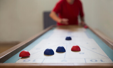 senior Playing the board game of shuffleboard.  Kidult gaming