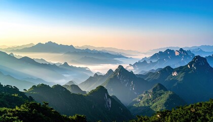 Verdant, jagged mountains pierce the sky, veiled in early morning mist and golden light, forming a breathtaking, serene panoramic vista