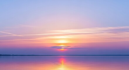 A serene sunset over a calm lake with a distant shoreline.