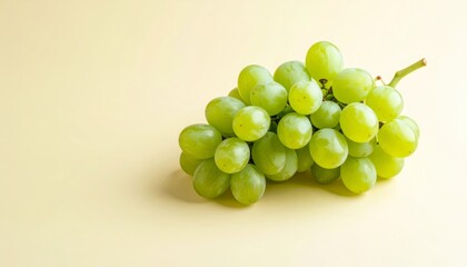 Lush green grapes, still life, against a soft, light yellow backdrop, studio shot.