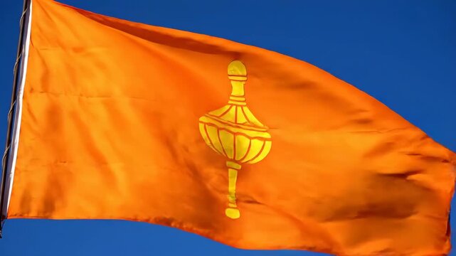 Vibrant saffron flag featuring lord hanumans sacred gada symbol waving proudly against a clear blue sky celebrating jayanti janmotsav