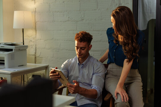 Colleagues using tablet and working together in modern office