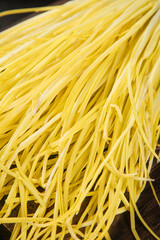 Fresh Yellow Pasta Noodles on Wooden Background - Homemade Italian Food Ingredient