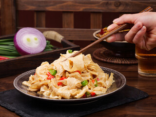 Fried Bean Skin Noodles with Chopsticks - Traditional Asian Cuisine on Wooden Table