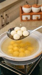 Fresh Dumplings Cooking in Boiling Water with Slotted Spoon in Kitchen
