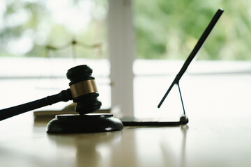 A judge's gavel placed on a wooden desk beside a laptop, symbolizing law, justice, court decisions, and legal proceedings in a modern office.